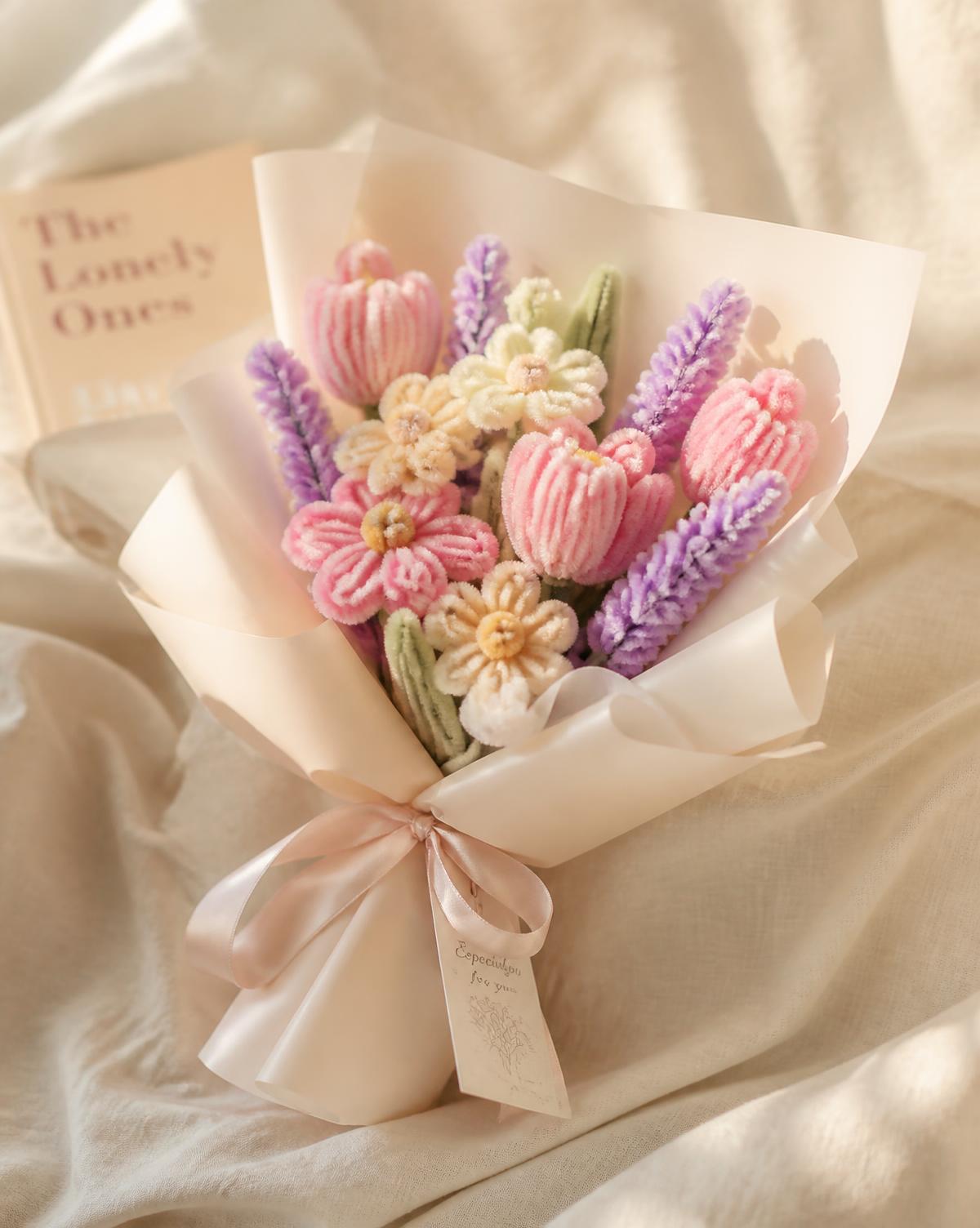 Pastel handmade pipe cleaner bouquet wrapped in ivory paper with a satin ribbon